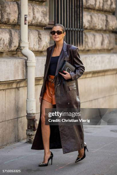 Darja Barannik wears brown leather short, brown shorts, black top, black bag outside Hermes during the Womenswear Spring/Summer 2024 as part of Paris...