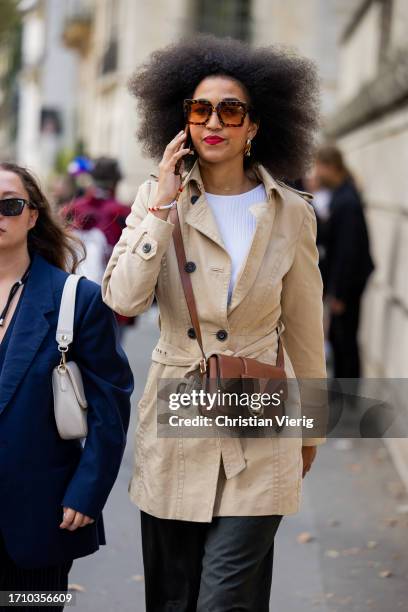 Guest wears brown Longchamp bag, trench coat outside Ellie Saab during the Womenswear Spring/Summer 2024 as part of Paris Fashion Week on September...