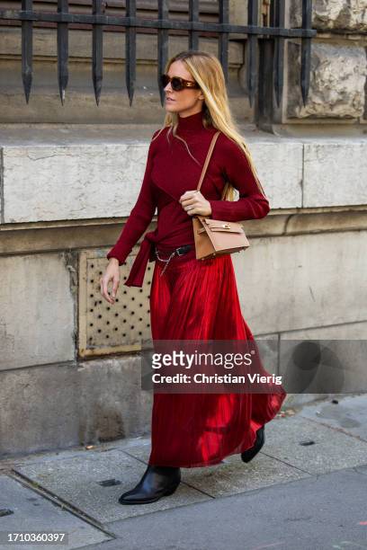 Blanca Miro Scrimieri wears red pleated skirt, turtleneck, brown bag outside Hermes during the Womenswear Spring/Summer 2024 as part of Paris Fashion...