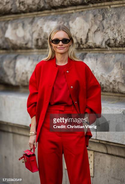 Claire Rose Cliteur wears red oversized college jacket, bag, pants wears outside Hermes during the Womenswear Spring/Summer 2024 as part of Paris...