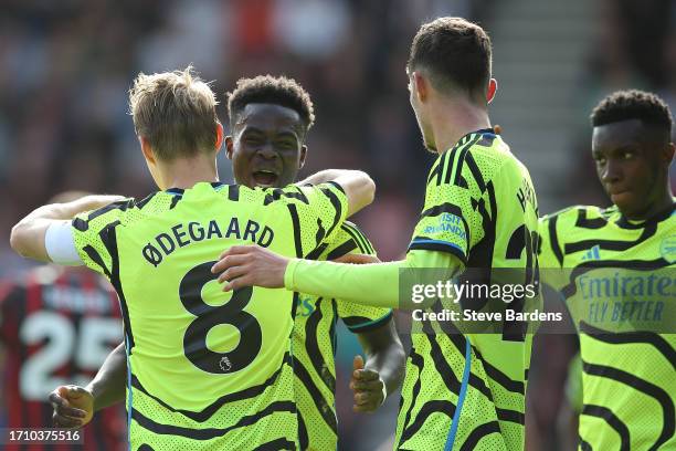 Martin Oedegaard of Arsenal celebrates with teammate Bukayo Saka after scoring the team's second goal from a penalty during the Premier League match...