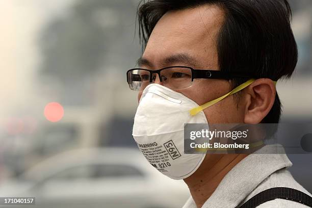 Man wears an N95 face mask in Singapore, on Friday, June 21, 2013. Singapore's smog hit its worst level, blanketing the city-state in thick, smoky...