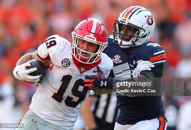 Brock Bowers of the Georgia Bulldogs breaks a tackle by Zion Puckett of the Auburn Tigers on the way to the go-ahead touchdownduring the fourth...