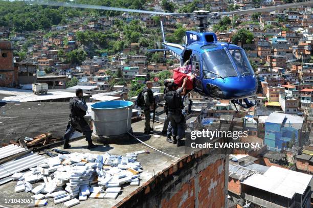 Riot Special Forces policemen load a helicopter with six tons of marijuana found in a bunker during a raid in the Morro do Alemao shantytown on...