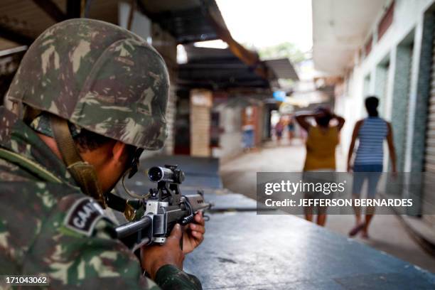 Brazilian Army soldier guards the entrance to the Morro de Alemao shantytown, on November 27, 2010 in Rio de Janeiro, Brazil. Rio's slums saw...