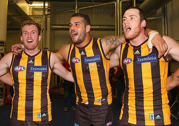 Xavier Ellis, Lance Franklin and Jarryd Roughead of the Hawks sing the songs in the rooms after winning the round 13 AFL match between the Hawthorn...