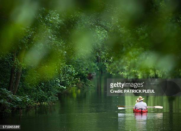 Two persons paddle over a canal near the village of Raddusch, eastern Germany, in the touristic Spreewald region on June 21, 2013. The Spreewald, a...