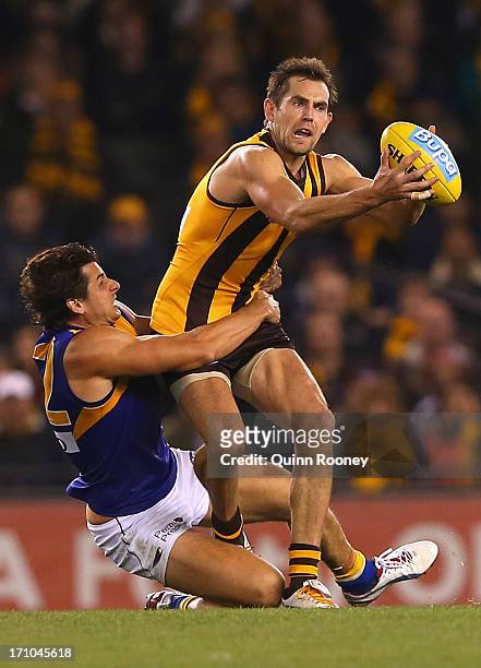 Luke Hodge of the Hawks is tackled by Andrew Embley of the Eagles during the round 13 AFL match between the Hawthorn Hawks and the West Coast Eagles...