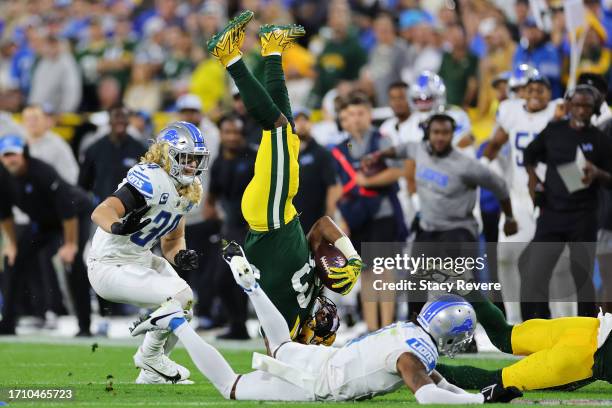 Aaron Jones of the Green Bay Packers is brought down by Cameron Sutton of the Detroit Lions during a game at Lambeau Field on September 28, 2023 in...