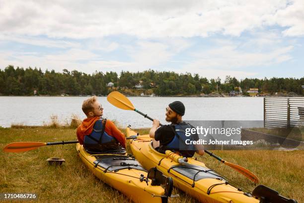 men sitting in kayaks at coast - kayaking stockholm stock pictures, royalty-free photos & images