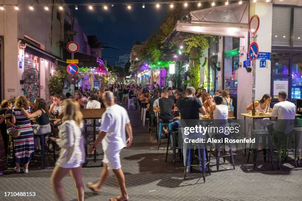 People fill the street while dining at an outdoor restaurant after the observant period of Sukkot ends and the intermediate days begin in Jaffa on...