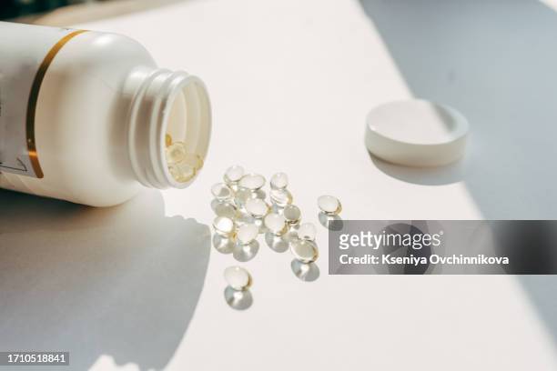 woman doctor nutritionist hands in white shirt with omega 3, vitamin d capsules with green vegan food. the doctor prescribes a prescription for medicines and vitamins at the clinic - d stock pictures, royalty-free photos & images