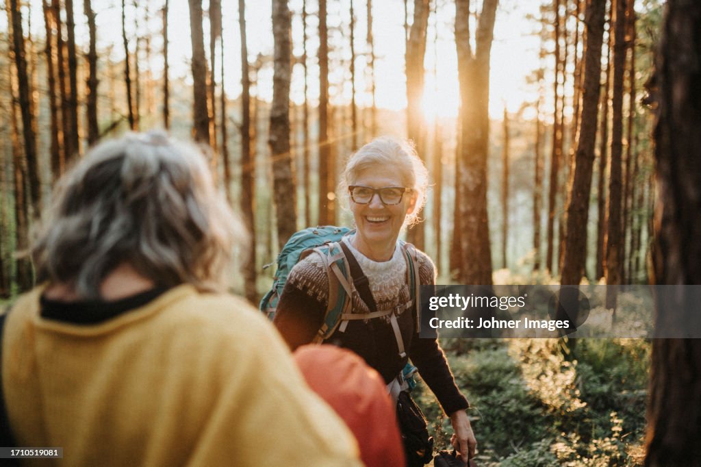 Two senior women hiking in forest