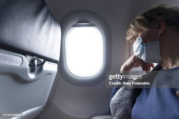 mature women flying by plane during coronavirus. - alex potemkin coronavirus stock pictures, royalty-free photos & images