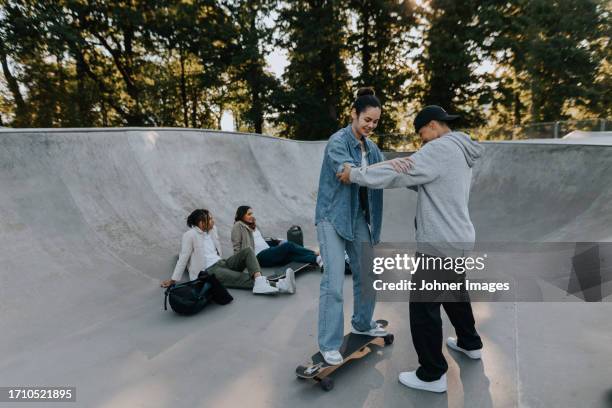 teenage girl learning how to skate in skate park - girl skateboard stock pictures, royalty-free photos & images