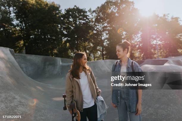 smiling teenage girls talking together at skate park - 19 to 22 years and friends and talking stock pictures, royalty-free photos & images