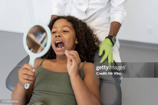 satisfied black girl after dental checkup. - plaque remover stock pictures, royalty-free photos & images