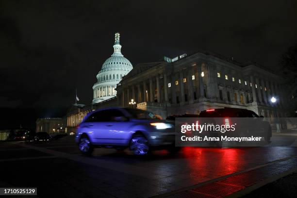 Cars drive pass the U.S. Capitol Building during a vote on a continuing resolution to fund the government on September 30, 2023 in Washington, DC....