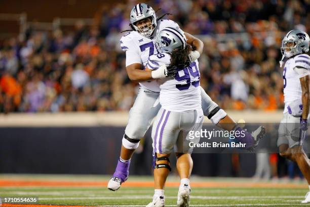 Leveston jumps into the arms of Uso Seumalo of the Kansas State Wildcats after blocking a field goal attempt by the Oklahoma State Cowboys in the...