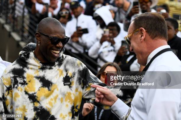 Former NFL player Terrell Owens has a word with University of Colorado athletic director Rick George before a game between the Colorado Buffaloes and...