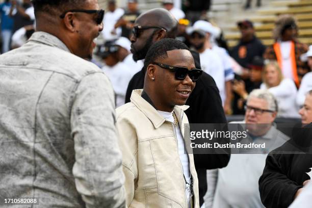 The rapper known as Symba stands on the sideline with former NBA players Paul Pierce and Kevin Garnett before a game between the Colorado Buffaloes...