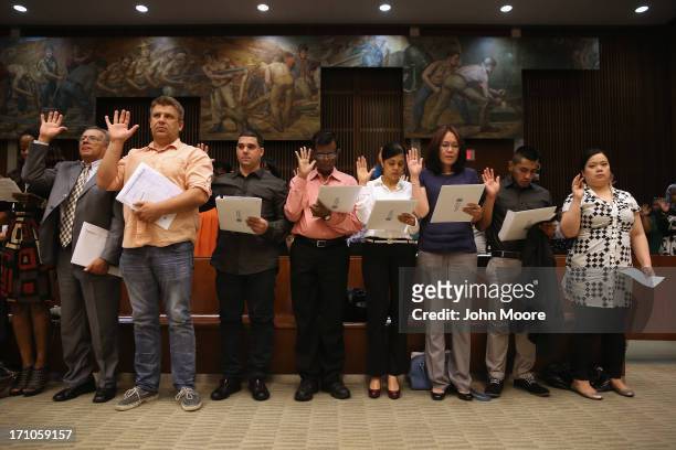 Immigrants sign their certificates of U.S. Citizenship before a naturalization ceremony on June 21, 2013 in the Brooklyn borough of New York City....