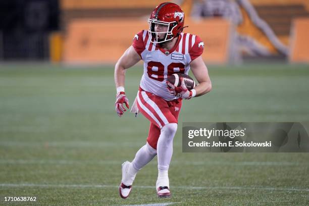 Cole Tucker of the Calgary Stampeders runs with the ball on a fumble recovery against the Hamilton Tiger-Cats during the first half at Tim Hortons...