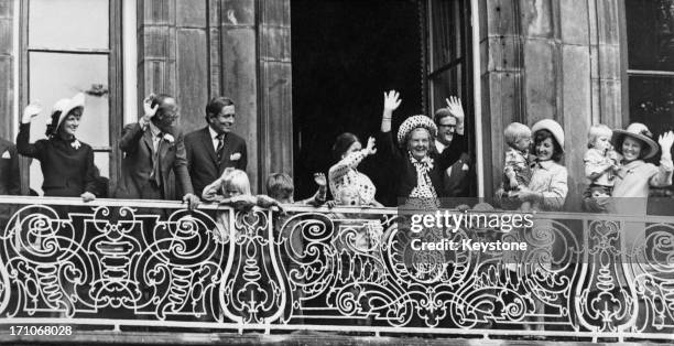 Queen Juliana of the Netherlands and members of the Dutch royal family wave from the balcony of the Lange Voorhout Palace in The Hague, during...