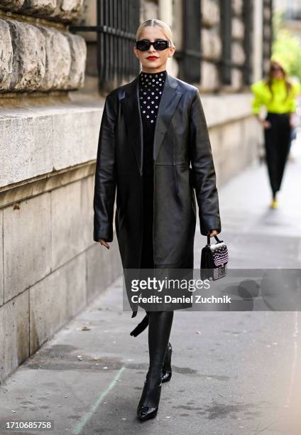 Caroline Daur is seen wearing a leather Hermes coat, black studded Hermes turtle neck and black and silver studded Hermes bag with black sunglasses...
