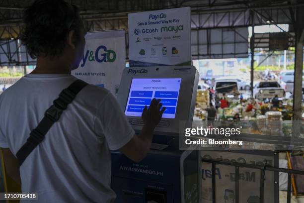 Customer uses a digital money transfer machine at a market in Quezon City, Manila, the Philippines, on Friday, Oct. 6, 2023. Rice inflation in the...