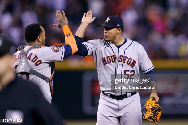 Bryan Abreu of the Houston Astros high fives Martin Maldonado after the Astros defeated the Arizona Diamondbacks 1-0 at Chase Field on September 30,...