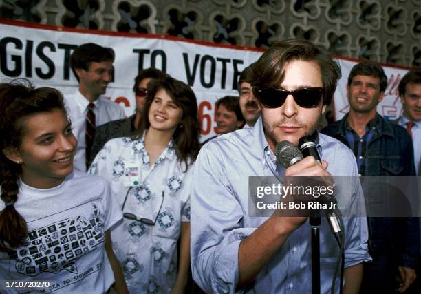 Actor Judd Nelson speaks to supporters as Actress Justine Bateman listens before boarding a Greyhound Bus for road trip to San Francisco with other...