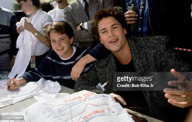 Actors Michael J Fox and Rob Lowe sign autographs for supporters before boarding a Greyhound Bus for road trip to San Francisco with other actors to...