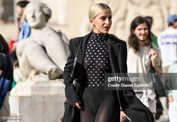 Caroline Daur is seen wearing an Elie Saab one piece, black coat, black stockings and black heels outside the Elie Saab show during the Womenswear...