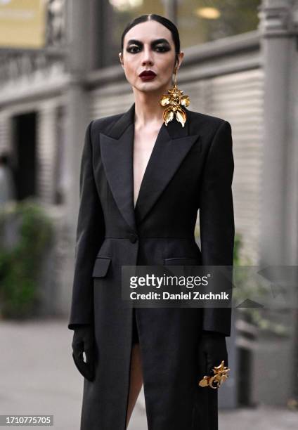 Guestis seen wearing an Alexander McQueen suit, gold earring and ring outside the Alexander McQueen show during the Womenswear Spring/Summer 2024 as...