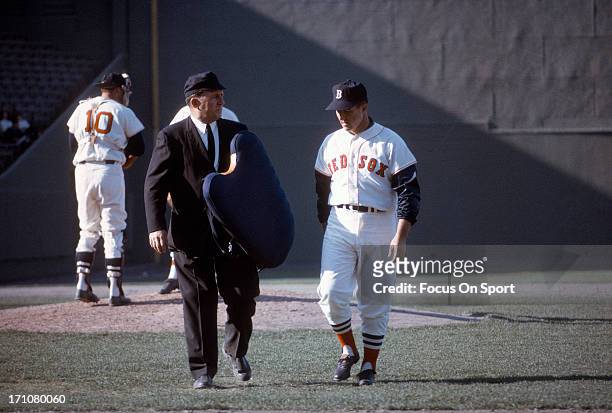 Manager Johnny Pesky of the Boston Red Sox walks off the field talking with the home plate umpire during a Major League Baseball game circa 1963 at...