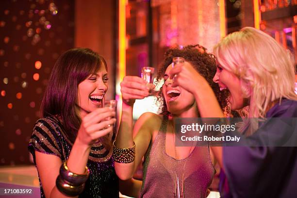 friends toasting shot glasses in nightclub - glamour shot stock pictures, royalty-free photos & images