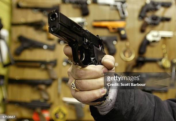 Man holds an Airsoft plastic BB gun in front of a shop display of the hobbyist replica firearms January 6, 2003 in London. British Home Secretary...