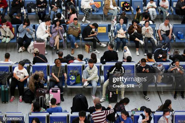 This photo taken on October 6, 2023 shows passengers waiting for trains on the last day of national holidays at Shenyang North Railway Station in...
