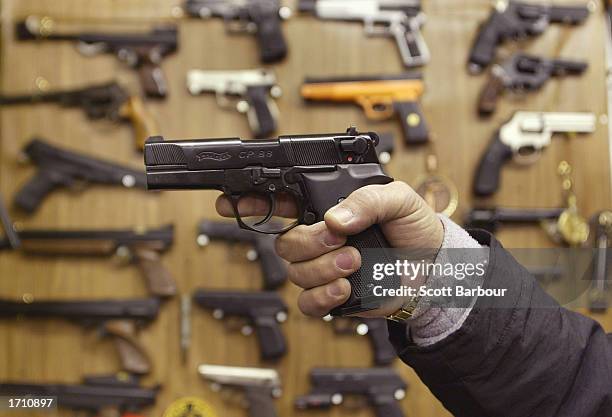 Man holds an Airsoft plastic BB gun in front of a shop display of the hobbyist replica firearms January 6, 2003 in London. British Home Secretary...