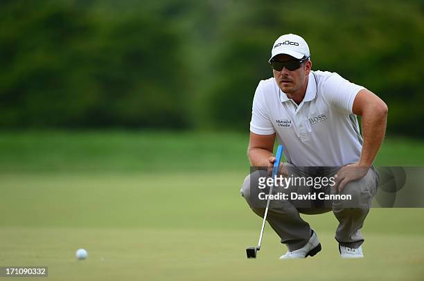 Henrik Stenson of Sweden lines up his putt on the first green during the final round of the 113th U.S. Open at Merion Golf Club on June 16, 2013 in...