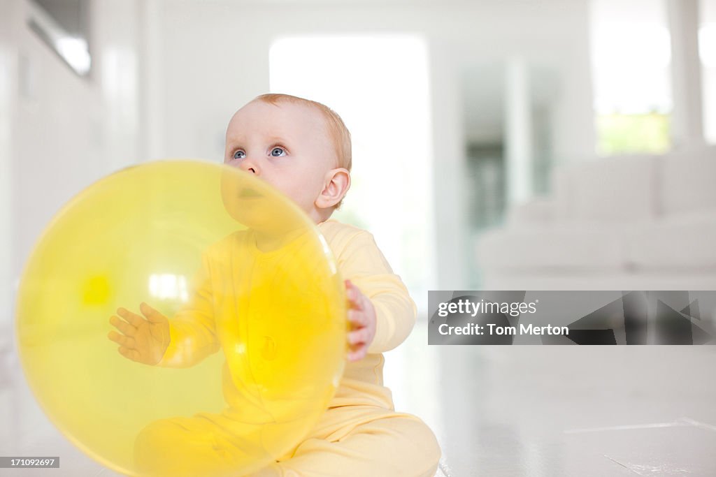 Curious baby with yellow balloon