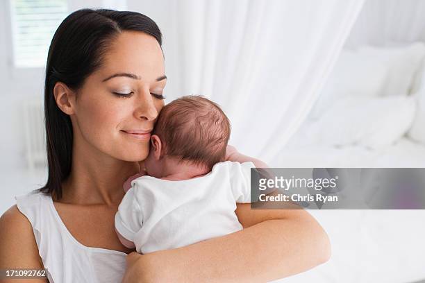 lächelnd mutter holding baby - mama latina stock-fotos und bilder