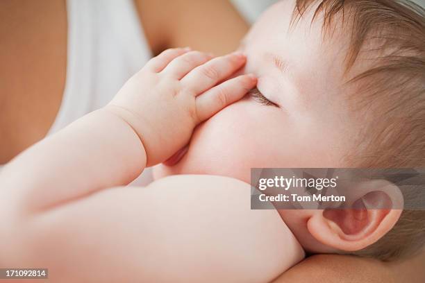 close up of sleeping baby sucking thumb - thumb sucking stock pictures, royalty-free photos & images