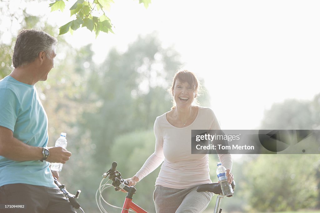 Couple on bicycles drinking water