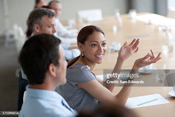 sonriente mujer de negocios gesticular en reunión en sala de conferencias - persuasión fotografías e imágenes de stock
