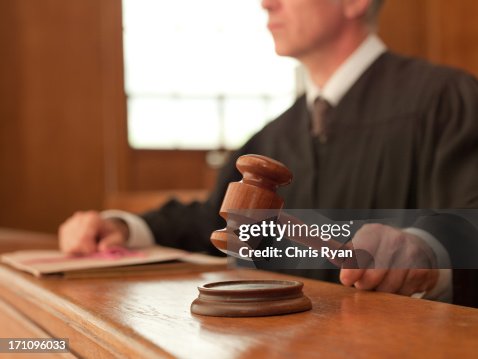 Judge holding gavel in courtroom Judge holding gavel in courtroom