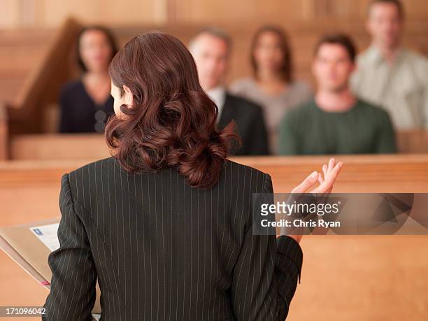 lawyer holding document and speaking to jury in courtroom - rättssal bildbanksfoton och bilder