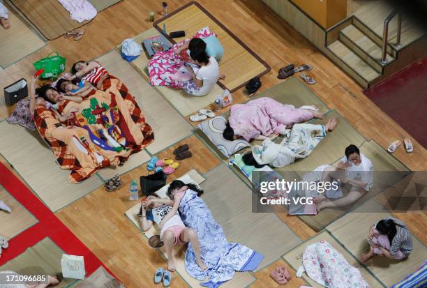 Students prepare to sleep on mats laid out on the floor inside a gymnasium at Huazhong Normal University on June 21, 2013 in Wuhan, Hubei province of...