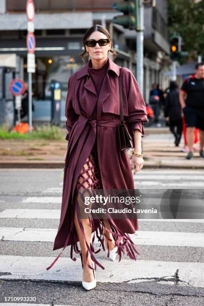 Guest, wearing burgundy trench coat, skirt and turtleneck sweater, is seen outside Ferragamo during the Milan Fashion Week - Womenswear Spring/Summer...